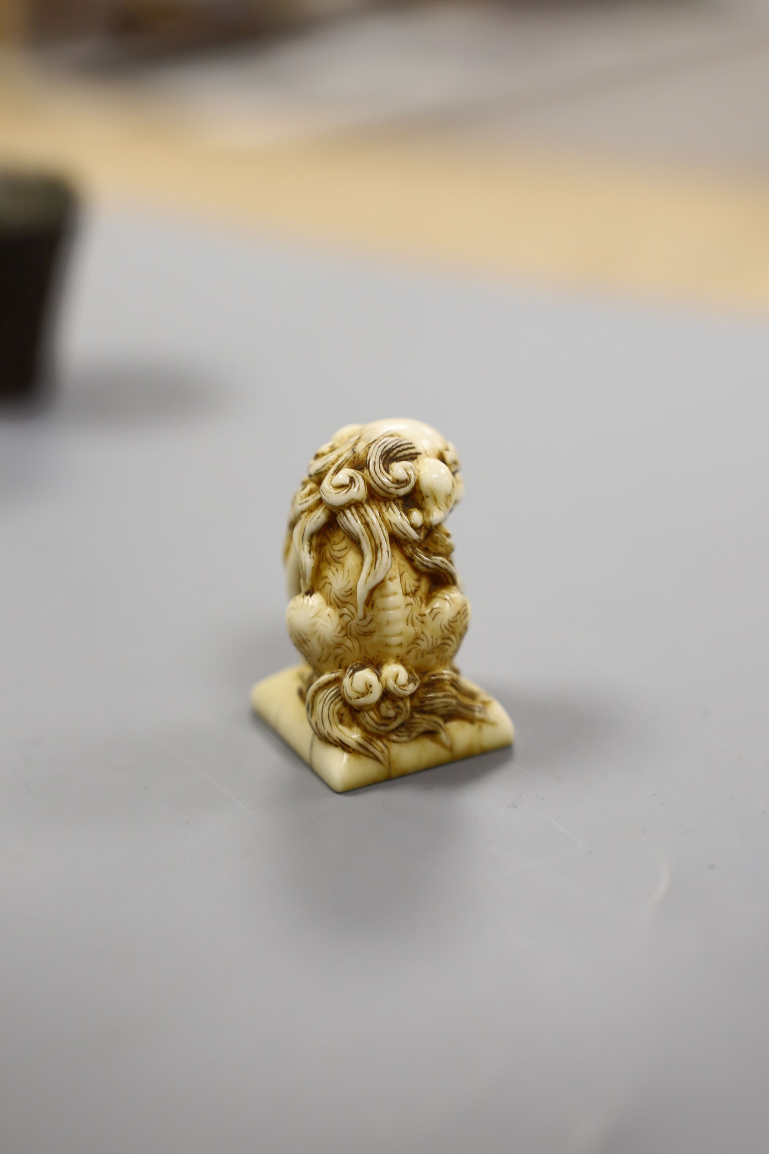A Chinese or Japanese ivory lion dog 18th/19th century and a Chinese carved nut cup, 19th century. 4cm